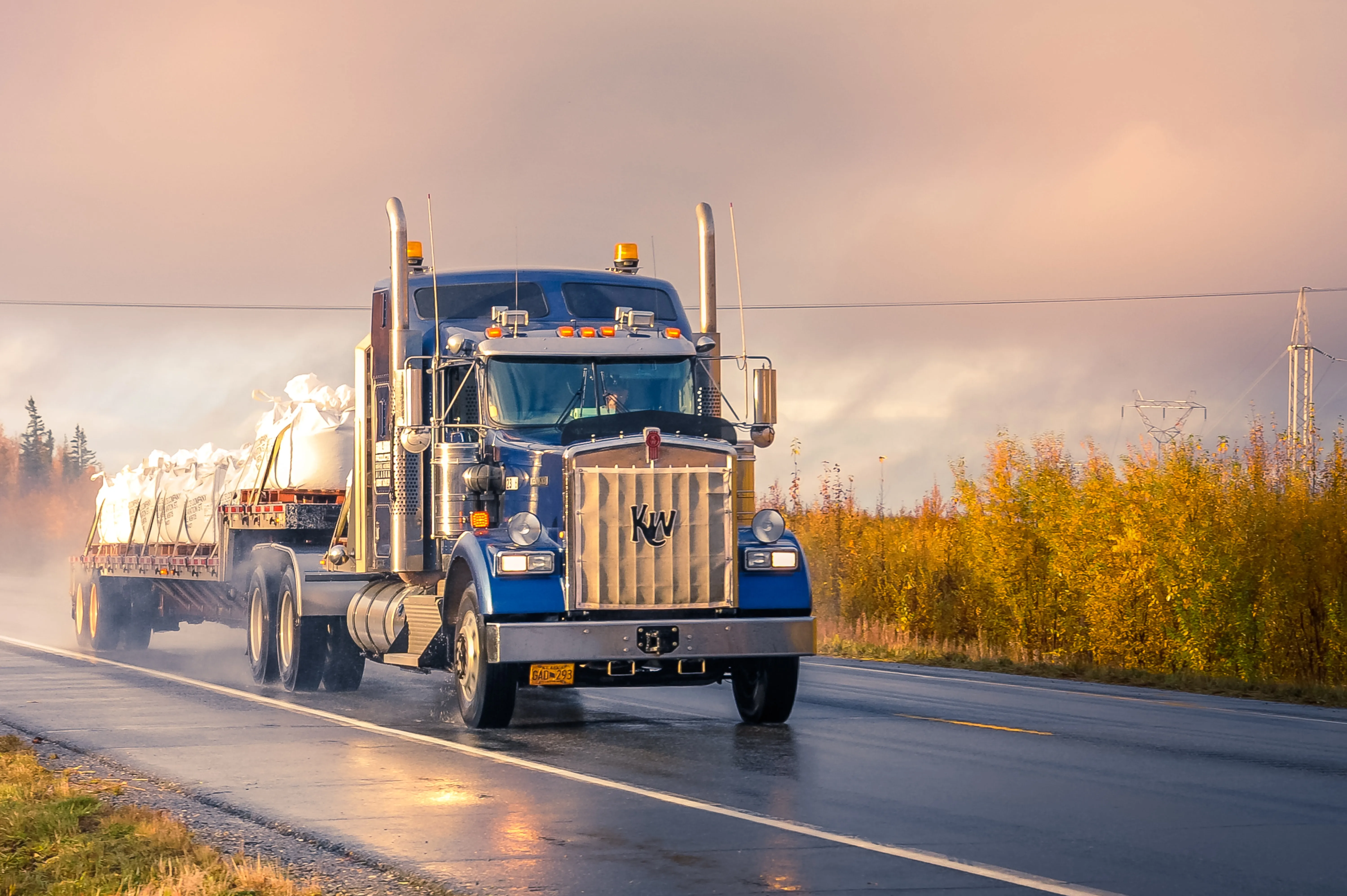 A tractor trailer truck on the highway after rain