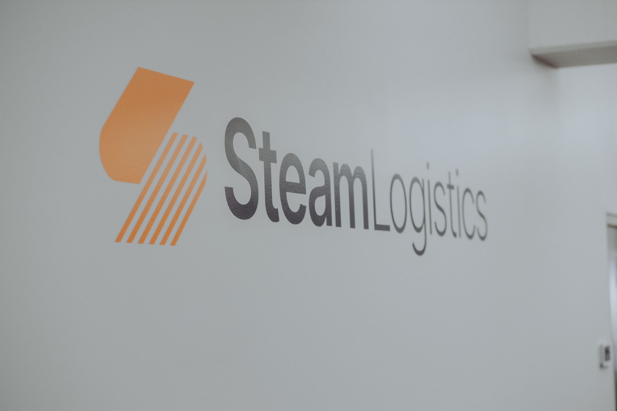 The Steam Logistics logo can be seen on the wall receding into the distance.